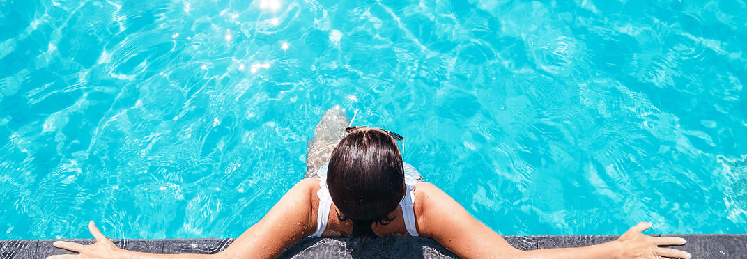 Femme dans une piscine d'eau turquoise
