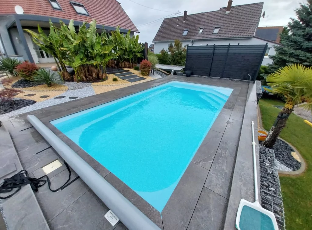 Piscine coque avec volet hors sol et aménagement extérieur