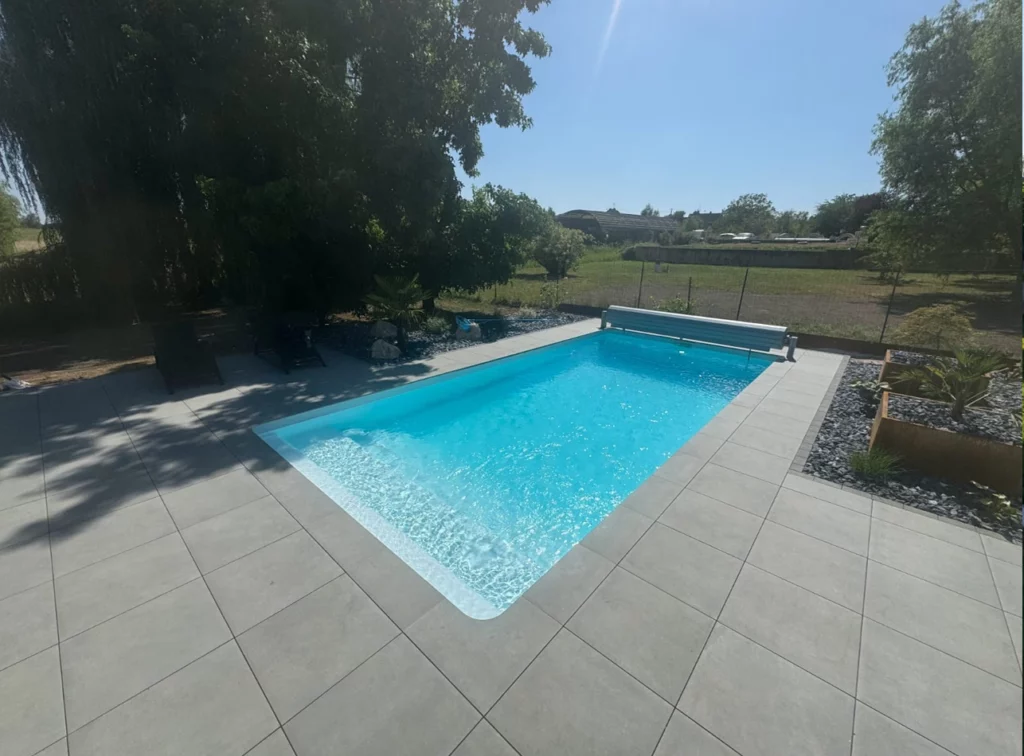 Piscine coque à Colmar avec dallage et volet hors sol.