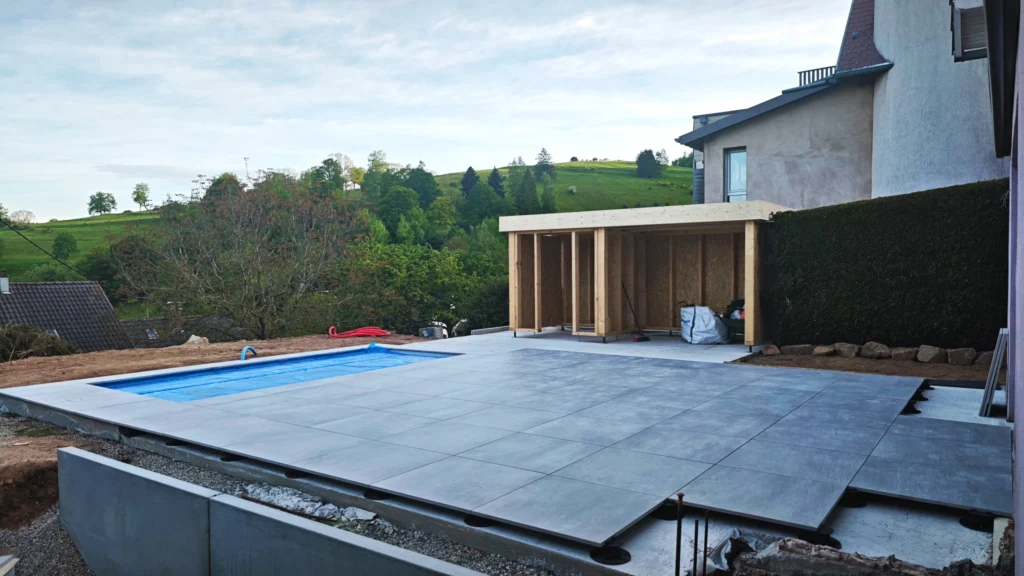 création d'une terrasse de 70 m² pour piscine à Grendelbruch. Dalles sur plots sur dalle de béton.